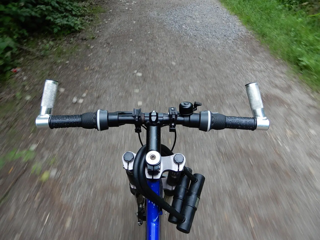 Cykelstyr set fra førerens perspektiv på en grusvej