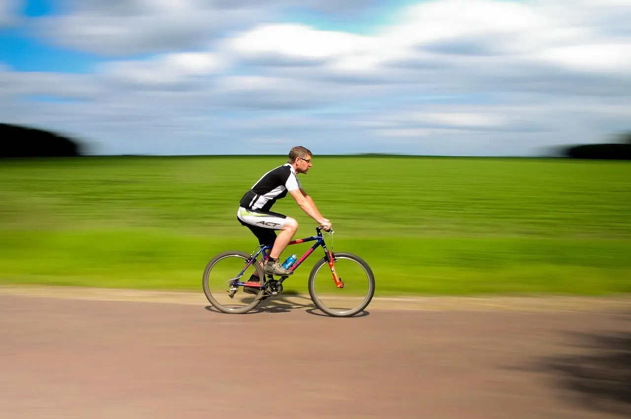 Mand på cykel i fart på en landevej