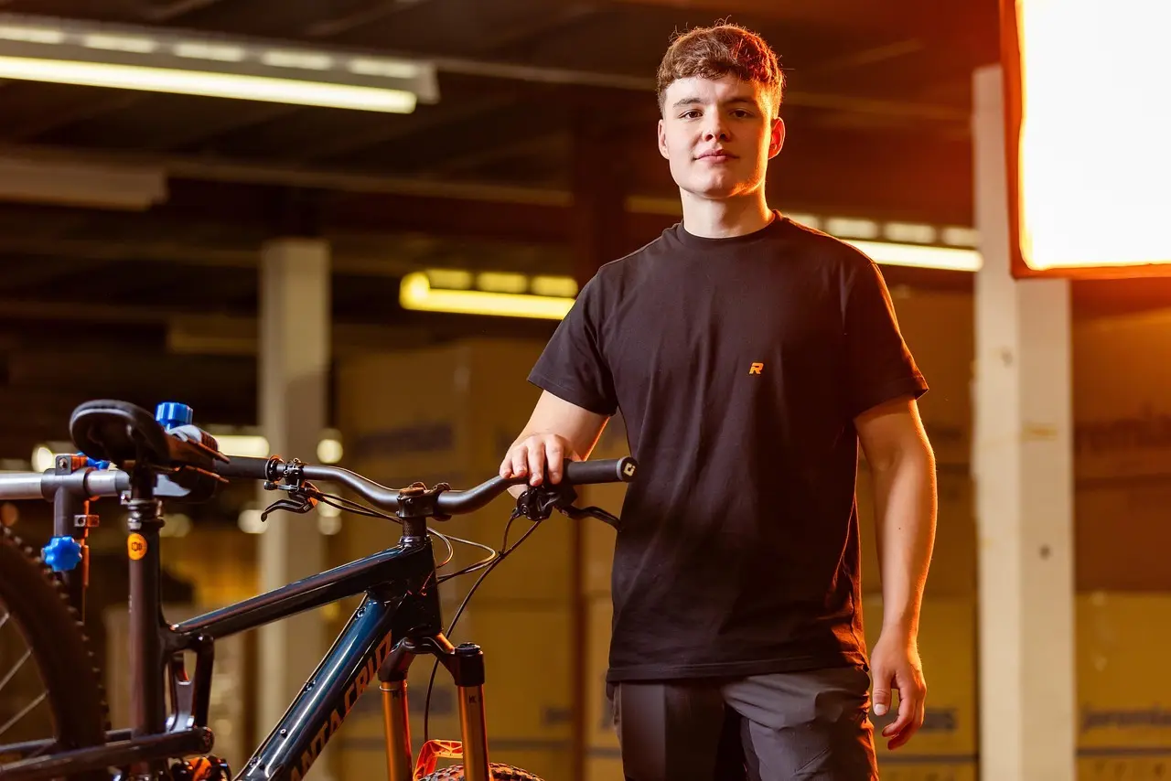 Ung mand stående ved en mountainbike
